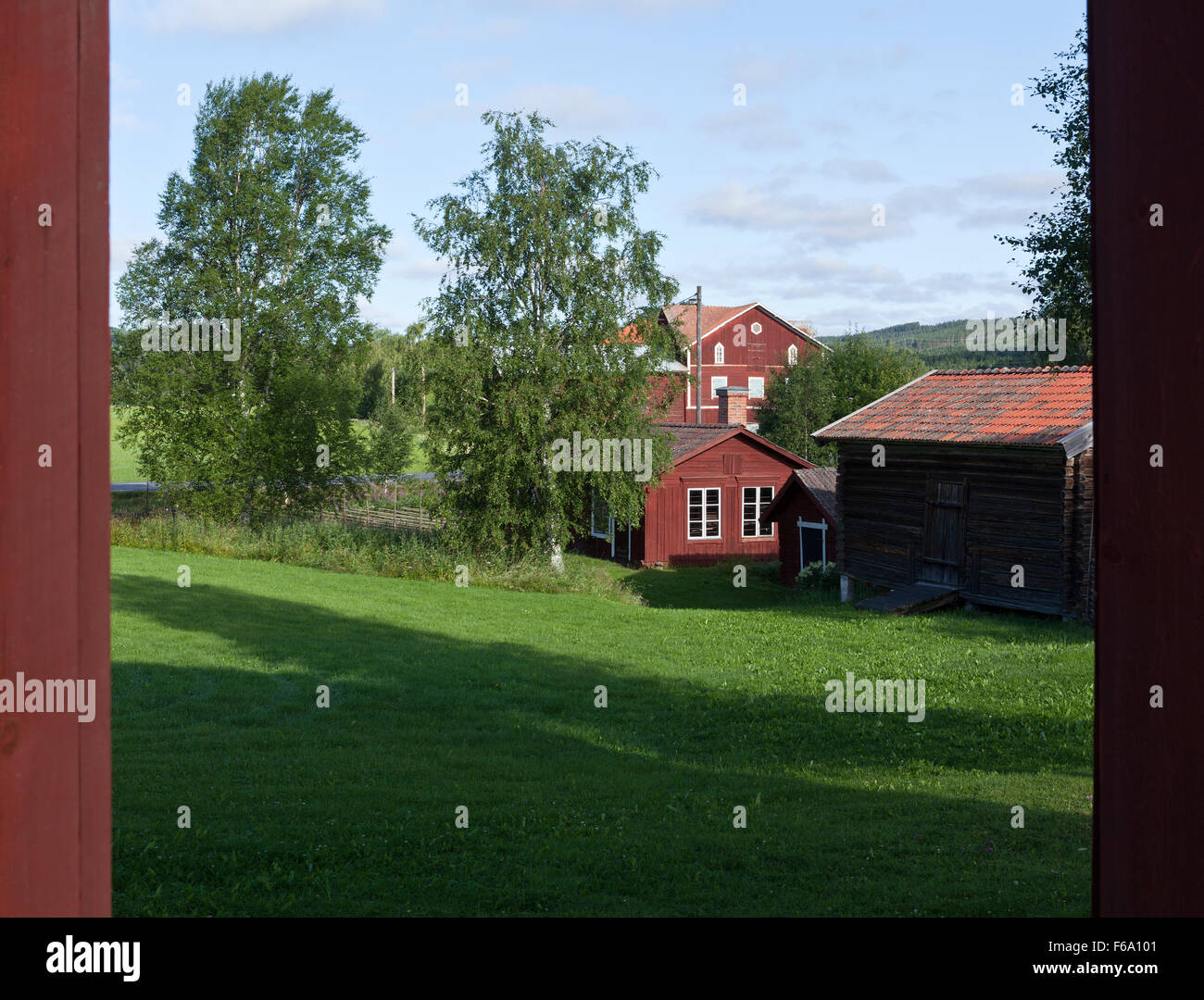 HALSINGLAND, SWEDEN ON JULY 24, 2015. View of a beautiful wooden homestead. Falu Red Paint colors and farmland. Editorial use. Stock Photo