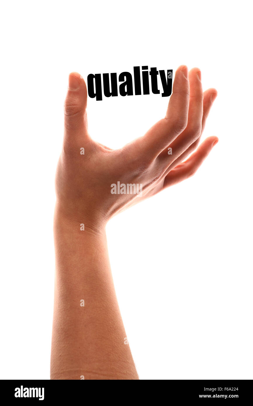 Color vertical shot of a of a hand squeezing the word "quality". Stock Photo