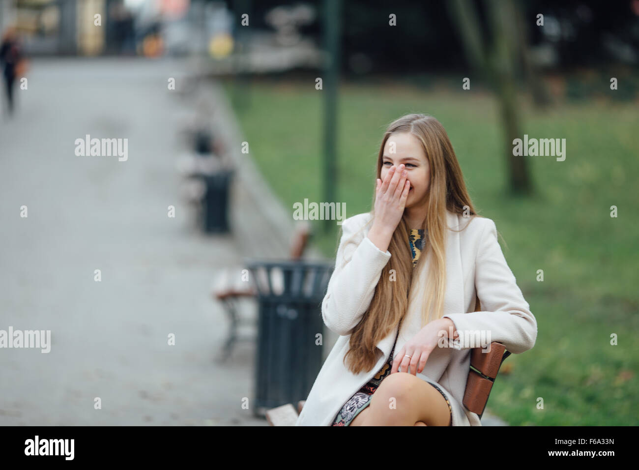 Young woman sitting on a bench in autumn park Stock Photo - Alamy