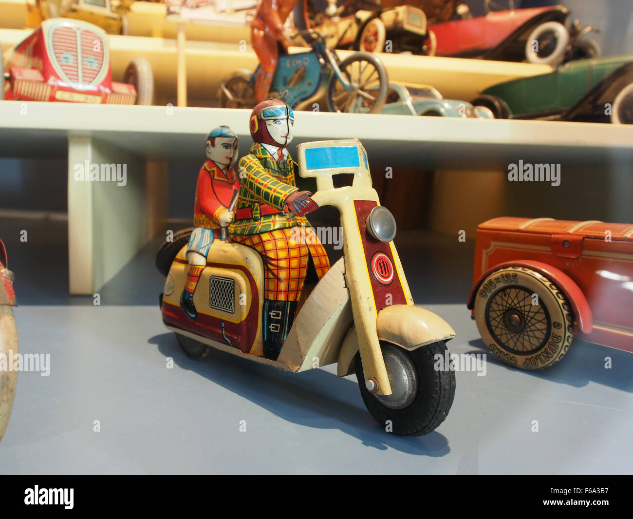 A vintage clockwork wind-up tin toy depicting an old scooter, on display at the Deventer Toy Museum, showcasing 20th-century toy craftsmanship and nostalgic design. Stock Photo