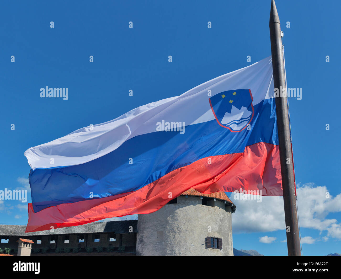 Slovenian national flag fluttering over Bled Castle Stock Photo