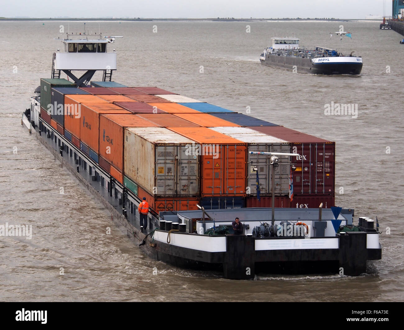 A photograph of the Berendrechtsluis, a large lock at the Port of Antwerp. The image captures a container ship in the lock, demonstrating the vital role the port plays in global logistics. The scene highlights the large-scale infrastructure that supports the transport of goods around the world. Stock Photo