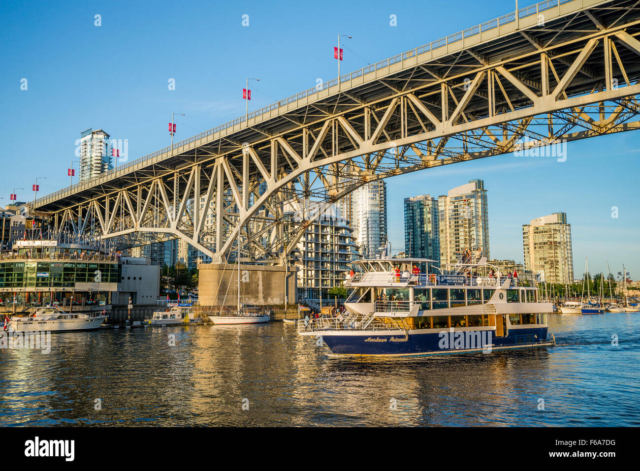 Tour boat passes under the Granville Bridge, Granville Island ...