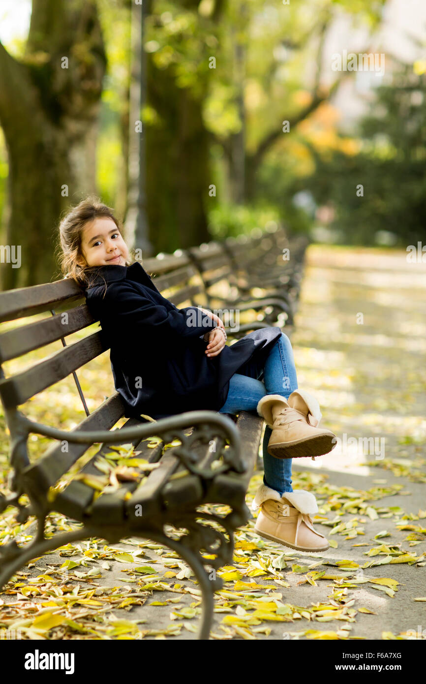 Little girl on the bench in the autumn park Stock Photo - Alamy