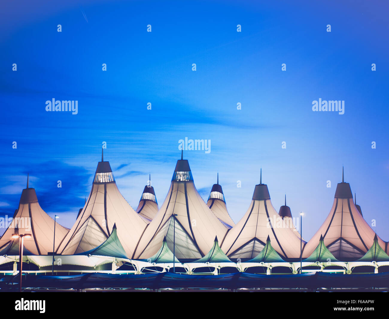 Glowing tents of DIA at sunrise. Denver International Airport well known for peaked roof. Design of roof is reflecting snow-capp Stock Photo
