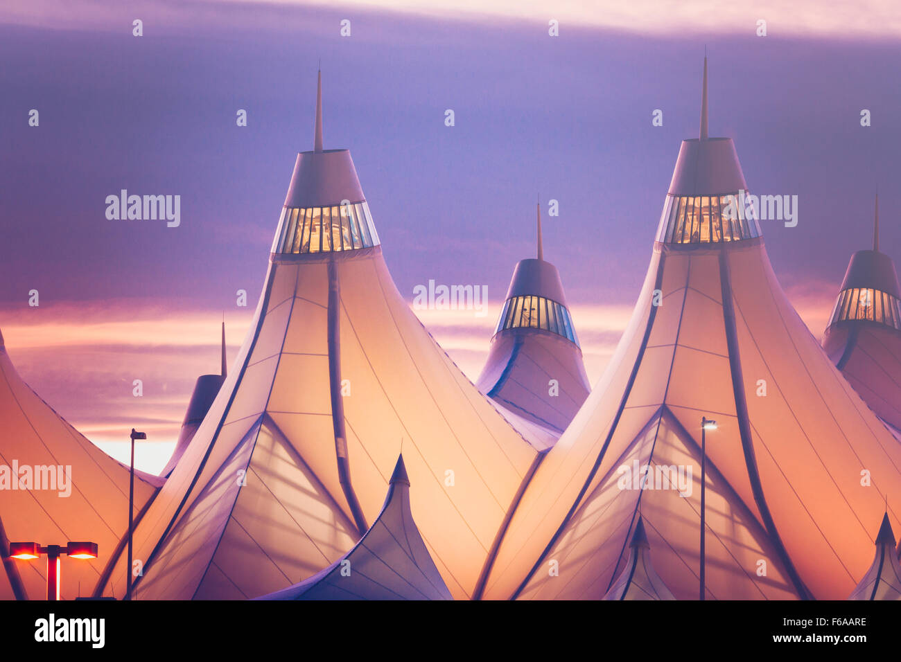 Glowing tents of DIA at sunrise. Denver International Airport well known for peaked roof. Design of roof is reflecting snow-capp Stock Photo