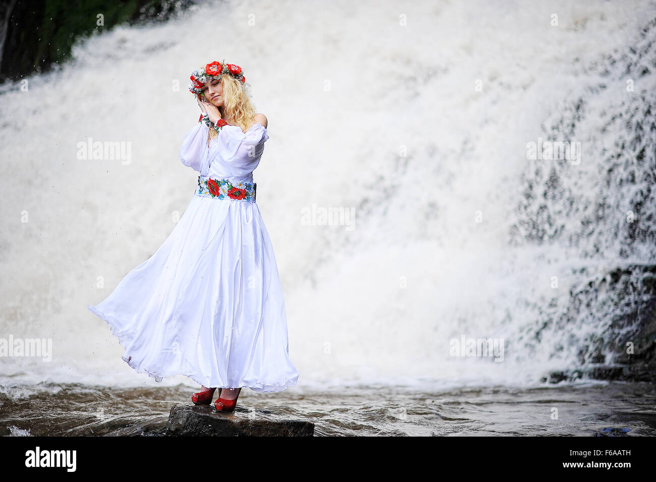 Young beautiful blonde girl in traditional dress stay under waterfall Stock  Photo - Alamy