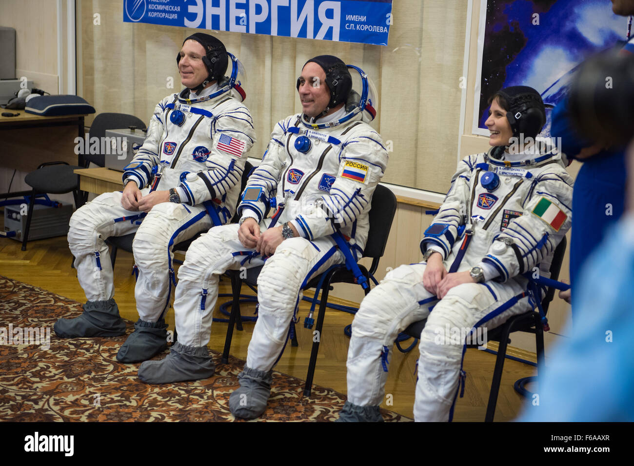 Expedition 42 crew members, Flight Engineer Terry Virts of NASA, left, Soyuz Commander Anton Shkaplerov of the Russian Federal Space Agency (Roscosmos), center, and Flight Engineer Samantha Cristoforetti of the European Space Agency (ESA), right, prepare for pressure checks of their Sokol suits in Building 254 following their suit up for launch, Sunday, Nov. 23, 2014, at the Baikonur Cosmodrome in Kazakhstan. Launch of the Soyuz rocket is scheduled for the early hours of Nov. 24 and will carry Virts, Shkaplerov, and Cristoforetti into orbit to begin their five and a half month mission on the I Stock Photo
