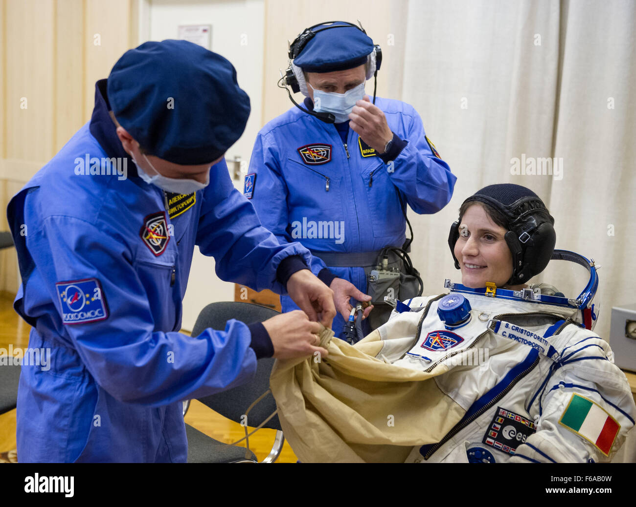 Expedition 42 Flight Engineer Samantha Cristoforetti of the European Space Agency (ESA) is helped into her Russian Sokol suit as she and fellow crewmates, Flight Engineer Terry Virts of NASA and Soyuz Commander Anton Shkaplerov of the Russian Federal Space Agency (Roscosmos), prepare for their Soyuz launch to the International Space Station, on Sunday, Nov. 23, 2014, at the Baikonur Cosmodrome in Baikonur, Kazakhstan. Launch of the Soyuz rocket is scheduled for the early hours of Nov. 24 and will carry Virts, Cristoforetti, and Shkaplerov into orbit to begin their five and a half month mission Stock Photo