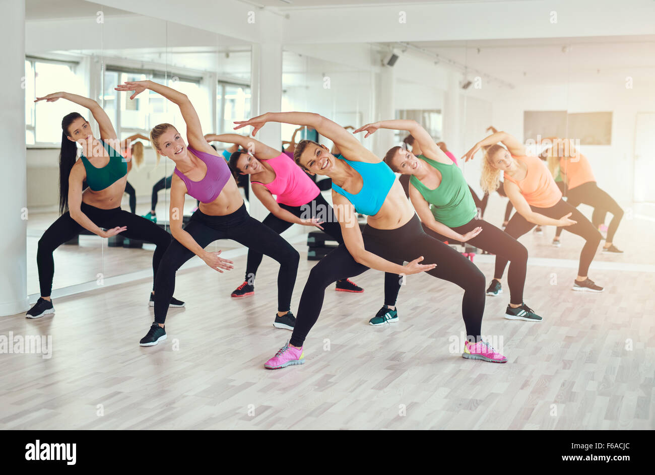 Aerobics class at a gym with a group of attractive fit young women in colorful sportswear working out in synchronisation, in a w Stock Photo