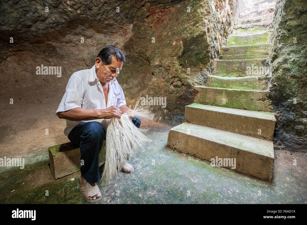 An artisan weaver begins work on a panama hat in a cave in Becal, Campeche, Mexico. Stock Photo