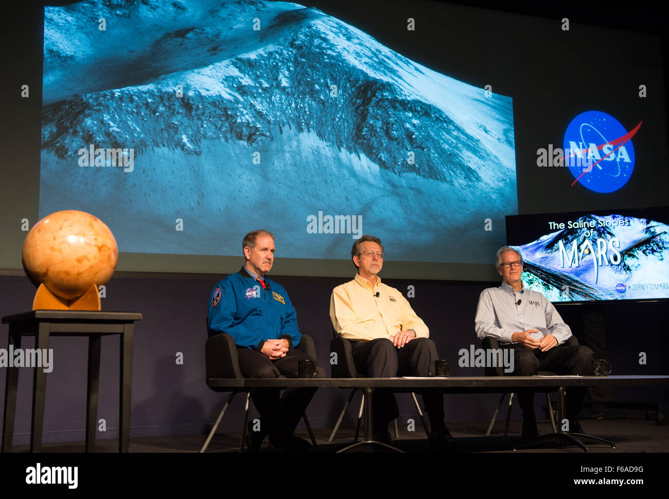 Panelists, from left to right, John Grunsfeld, associate administrator, science mission, NASA; Jim Green, director of planetary science, NASA; and Michael Meyer, lead scientist, Mars Exploration Program, NASA, listen to a presentation via phone by Mary Beth Wilhelm of NASA’s Ames Research Center at a news briefing announcing the presence of water on Mars on Monday, September 28, 2015 at NASA Headquarters in Washington, DC. The findings are being presented this week at the European Planetary Science Congress in France and are detailed in a research paper titled, "Spectral Evidence for Hydrated Stock Photo