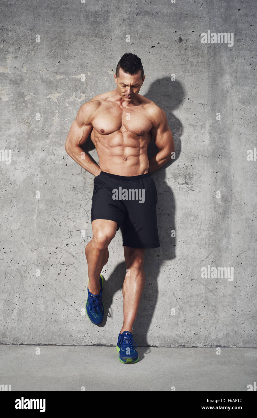 fitness-model-standing-against-grey-background-no-shirt-showing-abdominal-F6AF12.jpg