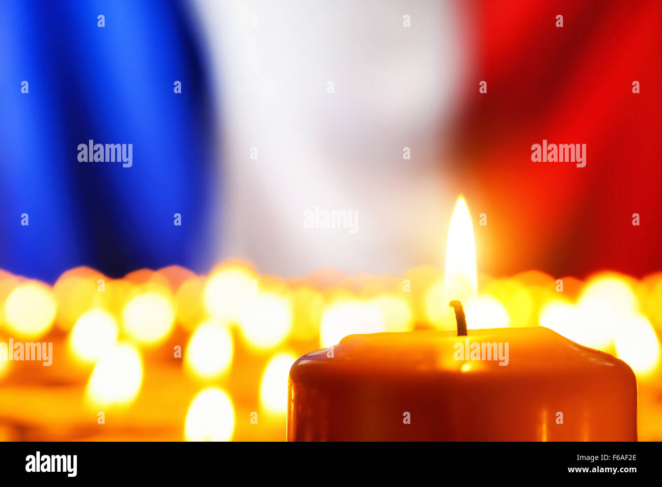 Lots of candles in front of the national colors of France in remembrance of the many victims of terror or to simply symbolize th Stock Photo