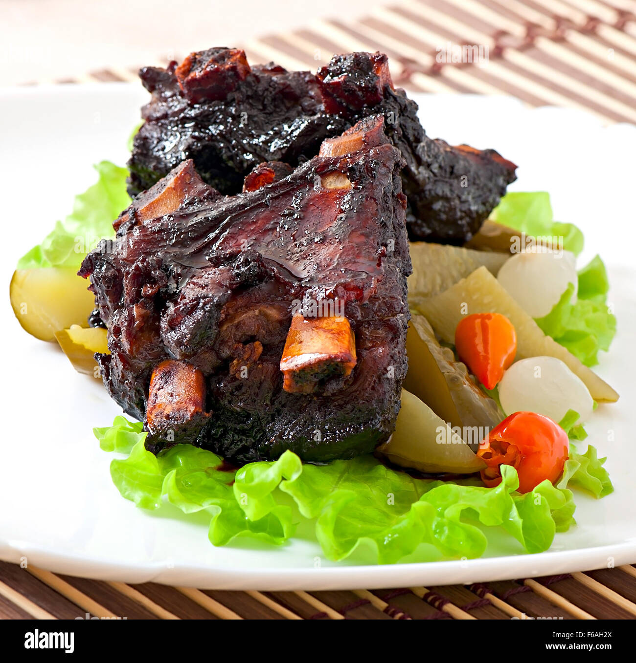 Baked beef ribs in honey soy marinade with pickled vegetables Stock Photo