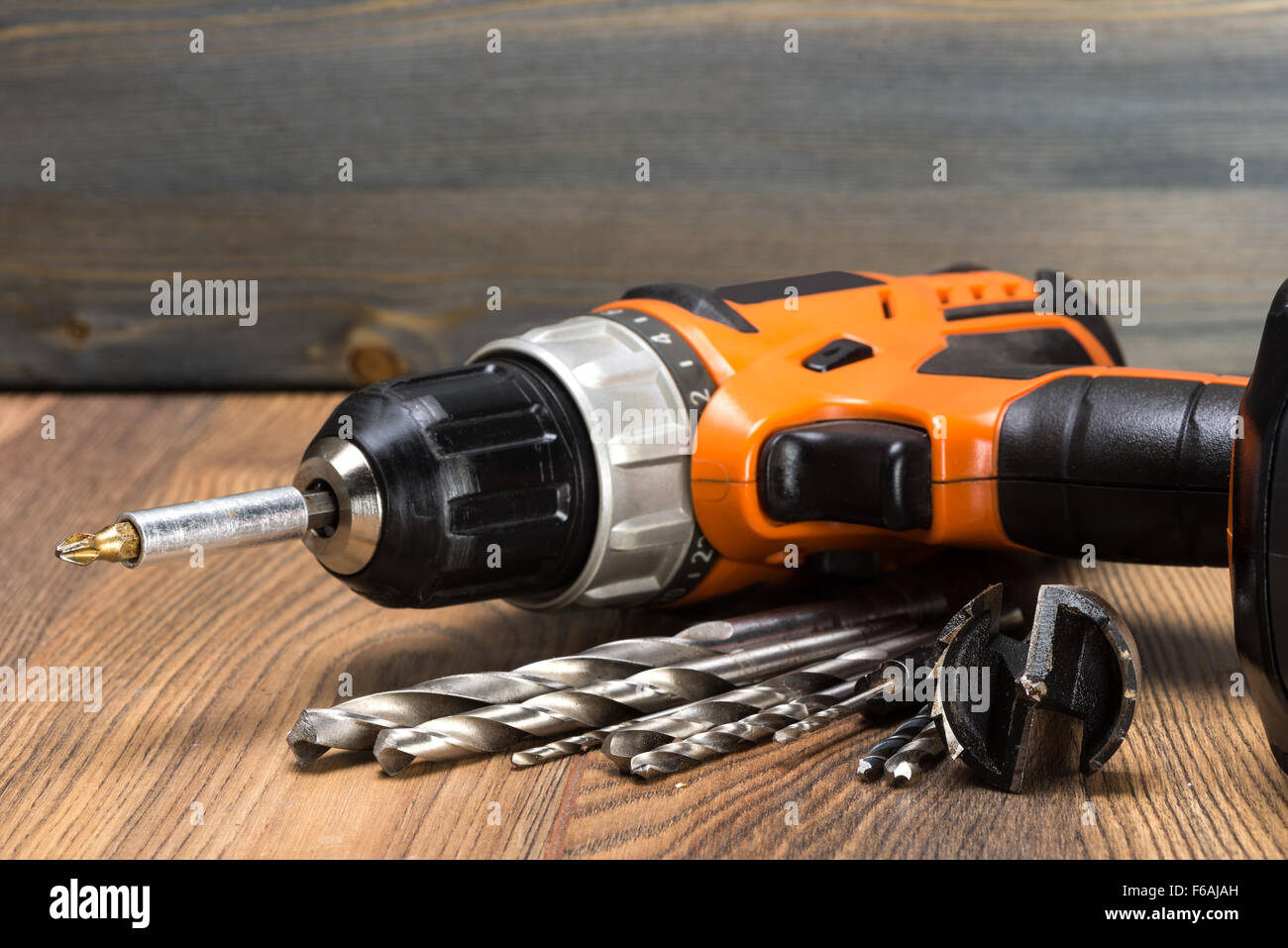 https://c8.alamy.com/comp/F6AJAH/battery-powered-drill-and-drill-on-a-wooden-surface-F6AJAH.jpg