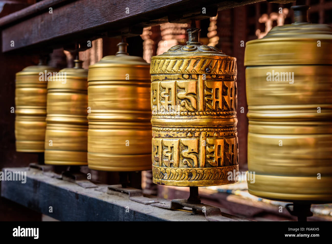 Golden tibetan prayer wheels in a Buddhist temple in Nepal Stock Photo