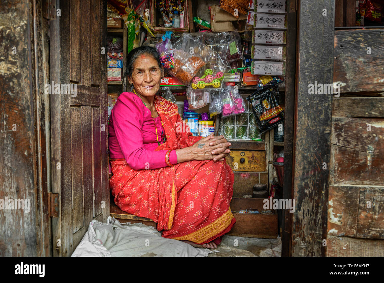 Old nepalese lady sells goods in her store. Stock Photo