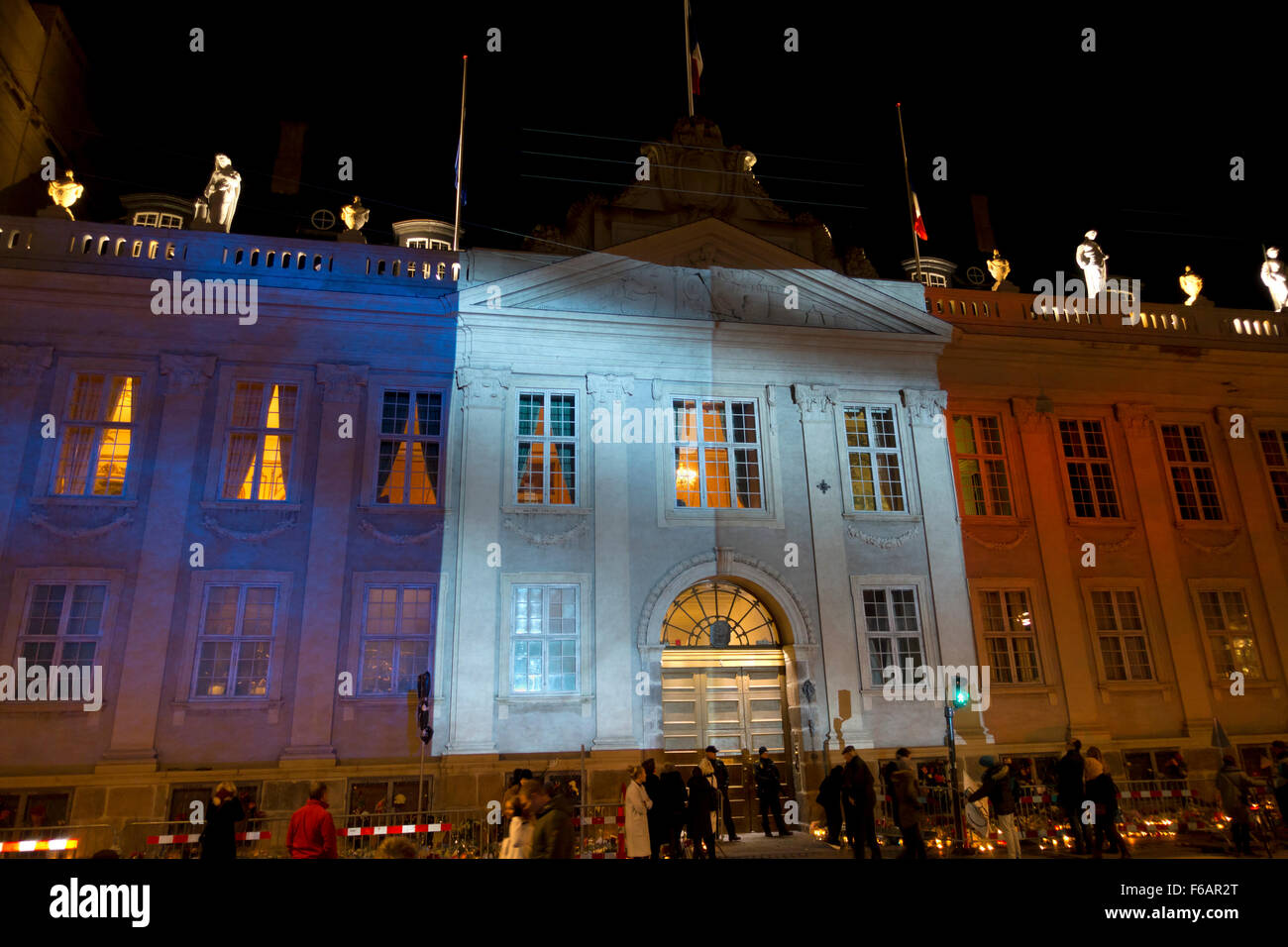 Copenhagen, Denmark, 15th November, 2015. Thousands of people in Copenhagen show their solidarity and sympathy with the French people outside the French Embassy in Copenhagen after last Friday's terror attacks in Paris. The huge amount of flowers and messages still grows this Sunday evening. Kongens Nytorv in Copenhagen is lit by the colours of the French Tricolore projected on the building of the still crowded French Embassy after a day of official memorial events and spontaneous actions of sympathy and solidarity. Credit:  Niels Quist/Alamy Live News Stock Photo