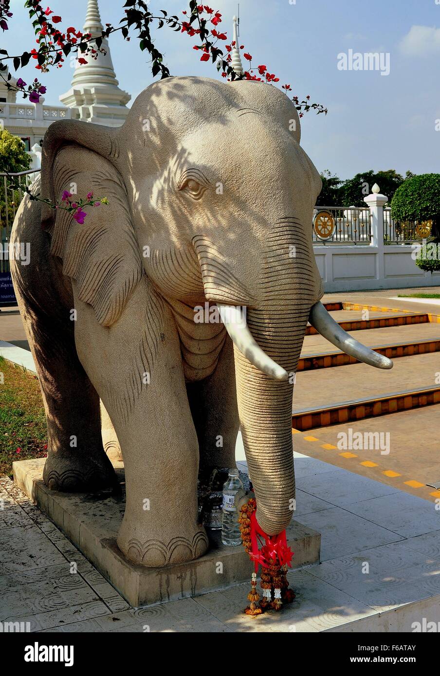 Samut Prakan, Thailand:  Statue of an elephant with several offerings left on its trunk at Wat Asoke Stock Photo