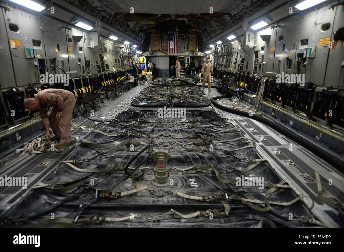 U.S. Air Force members prepare to pump fuel onto a C-17 Globemaster III ...
