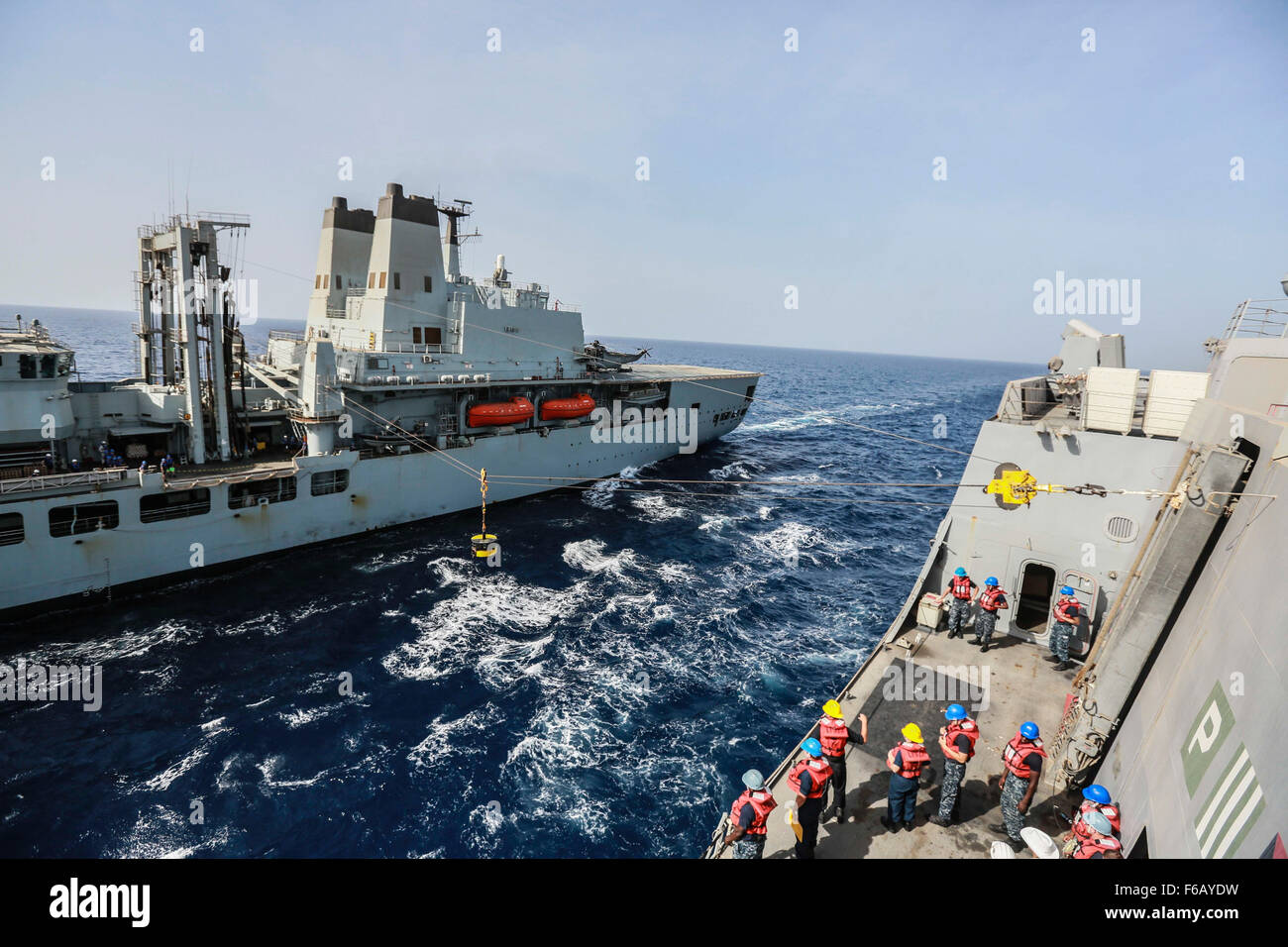 GULF OF ADEN (Aug. 20, 2015) The RFA Fort Victoria (A387) delivers a 2 ton test weight before it begins to deliver goods to the amphibious transport dock ship USS Anchorage (LPD 23) during a replenishment-at-sea. Elements of the 15th Marine Expeditionary Unit are embarked aboard the Anchorage, which is part of the Essex Amphibious Ready Group, and are deployed in support of maritime security operations and theater security cooperation efforts in the U.S. 5th Fleet area of operations.  (U.S. Marine Corps photo by Sgt. Steve H. Lopez/  Released) Stock Photo