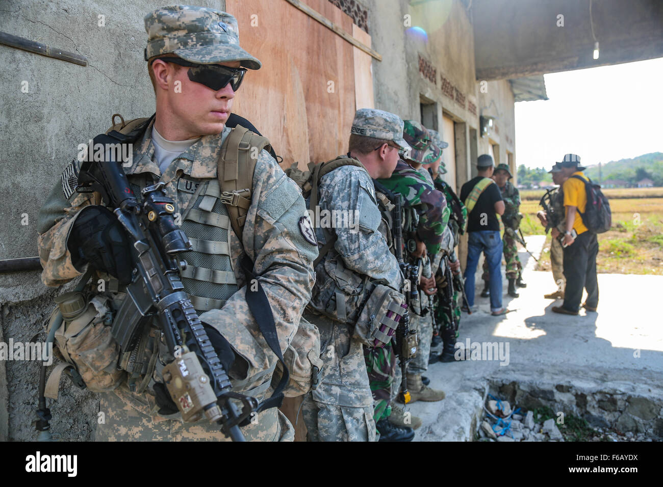 U.S. Army Spc. Conor Bonaventure, an Infantryman from Bravo Company 2-27th Infantry Regiment 3rd Infantry Brigade 25th Infantry Division, stands in the position of rear security that is preparing to search a house alongside Indonesian Soldiers from 1st Infantry Division of Kostrad during Garuda Shield, Pacific Pathways 2015 at Cibenda, West Java, Indonesia, on Aug. 21, 2015.  Garuda Shield is a regularly scheduled bilateral exercise sponsored by U.S. Army-Pacific, hosted annually by the Tentara Nasional Indonesia Army to promote regional security and cooperation.  (U.S. Army Photo by Spc. Mich Stock Photo