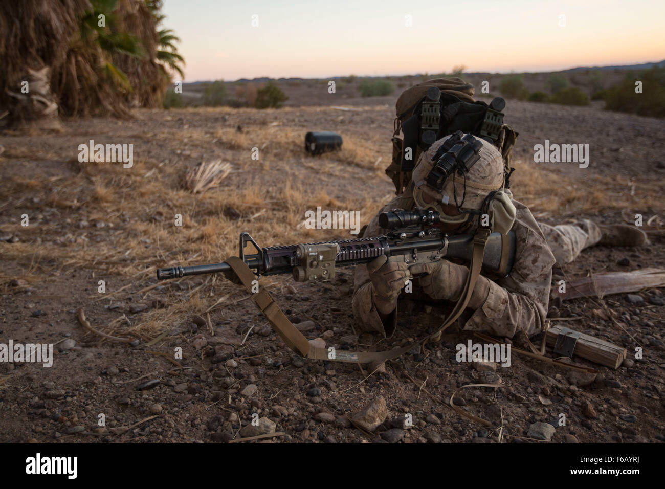U.S. Marine Corps Lance Cpl. Eduardo Gomez with 2nd Battalion, 7th Marine Regiment, 1st Marine Division, provides security during a Heavy Huey Raid at K-9 Village, Yuma Proving Grounds, Yuma, Ariz., Oct. 7, 2015. This exercise was part of the Weapons and Tactics Instructor (WTI) 1-16, a seven week training event, hosted by Marine Aviation Weapons and Tactics Squadron One (MAWTS-1) cadre, which emphasizes operational integration of the six functions of Marine Corps aviation in support of a Marine Corps Air Ground Task Force. MAWTS-1 provides standardized advanced tactical training and certifica Stock Photo