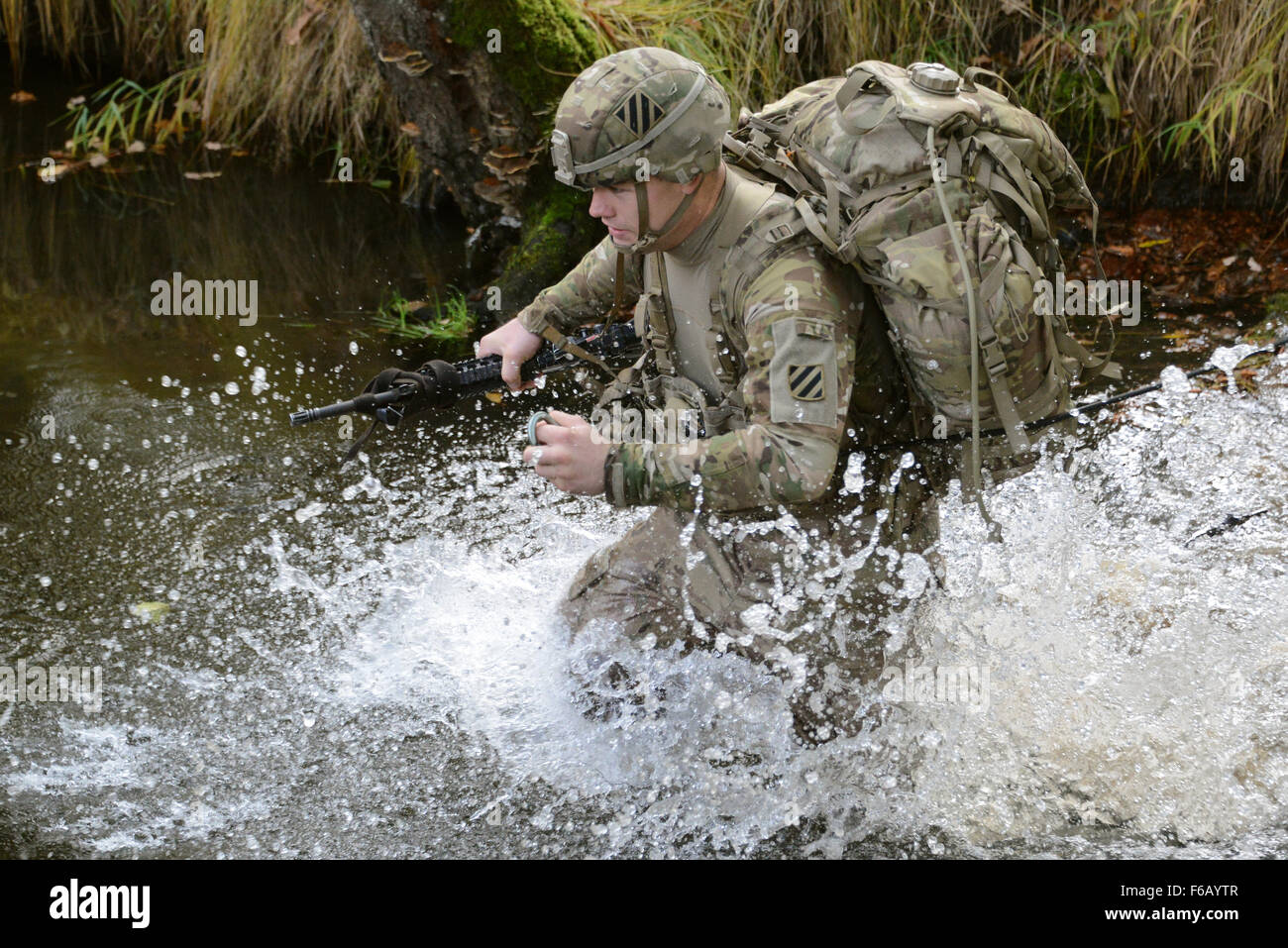 A U.S. Soldier, assigned to 1st Armored Brigade Combat Team, 3rd Infantry Division, conducts the rope bridge water crossing lane during the European Best Squad Competition at the 7th Army Joint Multinational Training Command, Grafenwoehr training area, Bavaria, Germany, Oct. 20, 2015. The European Best Squad Competition is an Army Europe competition challenging militaries from across Europe to compete and enhance teamwork with Allies and partner nations.  (U.S. Army photo by Visual Information Specialist Gertrud Zach/released) Stock Photo