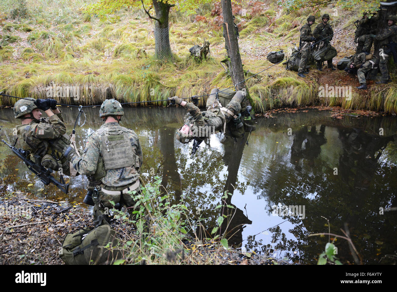 German soldiers conduct the Rope Bridge Water Crossing lane during the European Best Squad Competition at the 7th Army Joint Multinational Training Command’s Grafenwoehr training area, Bavaria, Germany, Oct. 21, 2015. The European Best Squad Competition is an Army Europe competition challenging militaries from across Europe to compete and enhance teamwork with Allies and partner nations.  (U.S. Army photo by Visual Information Specialist Gertrud Zach/released) Stock Photo