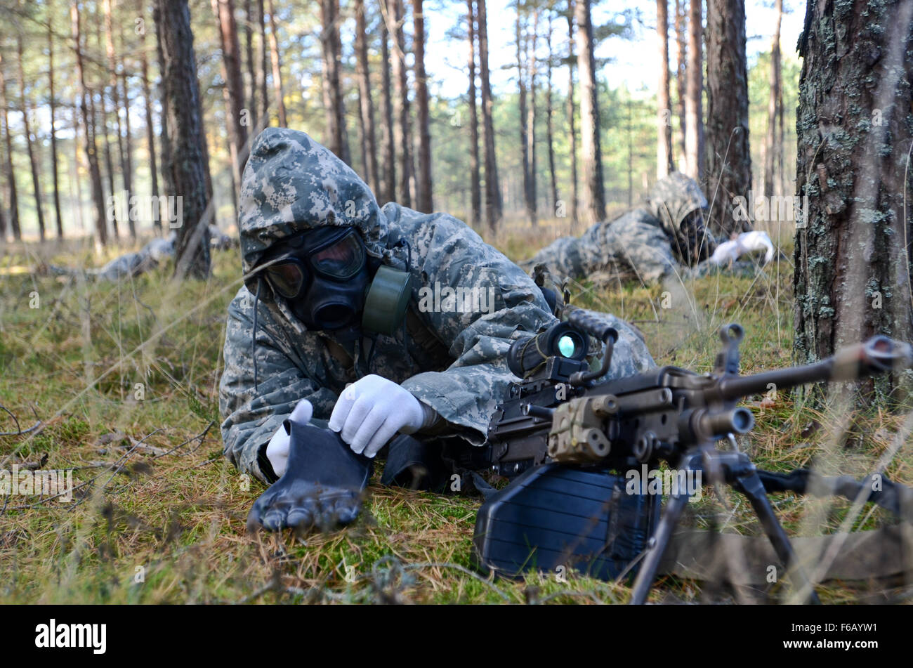 A Soldier with Attack Company 1-503rd Infantry Regiment (Abne), 173rd Airborne Brigade, Italy, don their gloves during a Chemical, Biological, Radiological, Nuclear training exercise in Latvia, Oct. 21, 2015, in support of Operation Atlantic Resolve. OAR provides U.S. Soldiers the opportunity to work with and train alongside our NATO allies, forge relationships that foster trust and mutual understanding, strengthen interoperability, and demonstrate the United States’ commitment to the NATO Alliance. Stock Photo