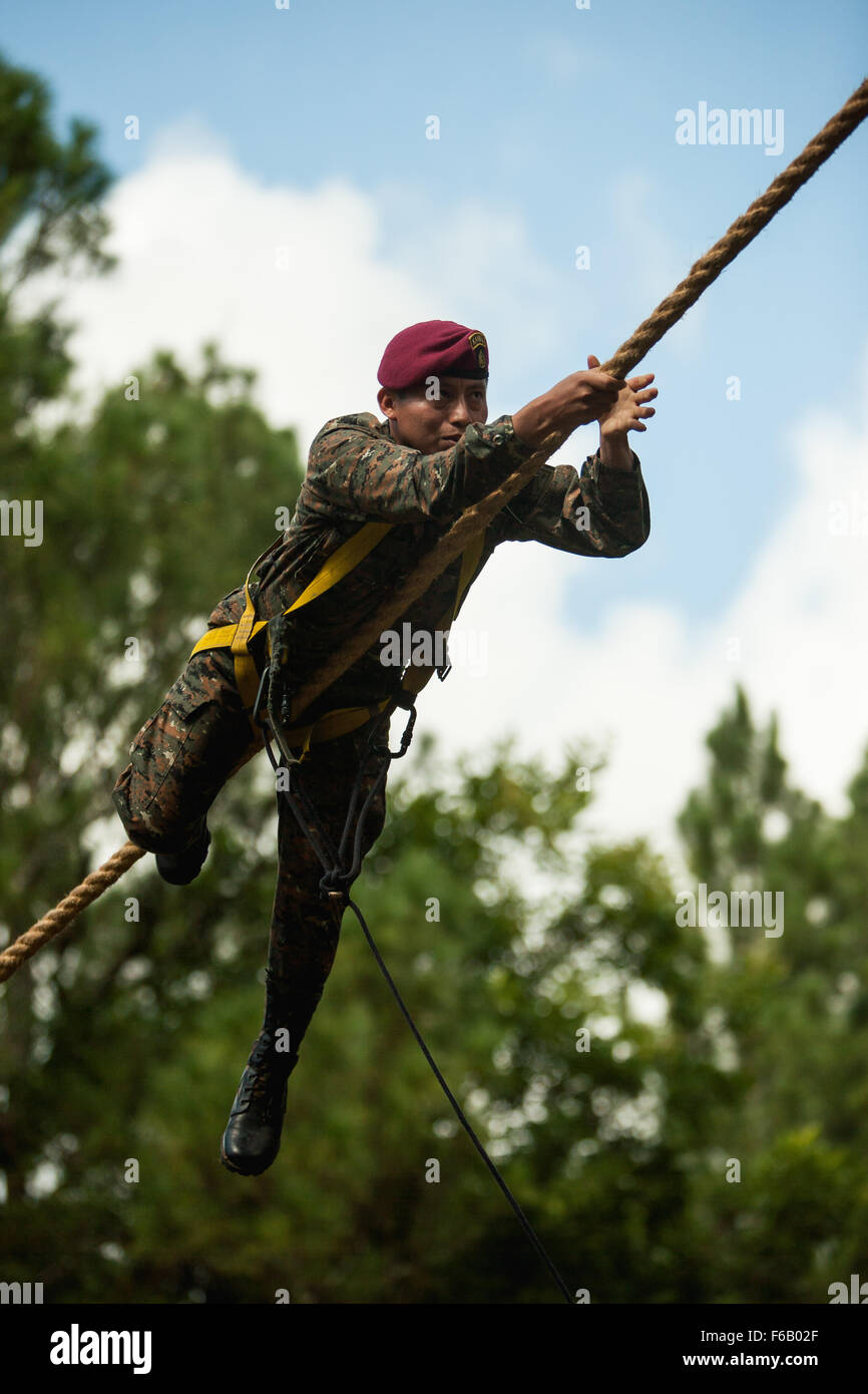 A Guatemalan Kaibil demonstrates how to overcome a rope obstacle July 19, 2015, during this year's Fuerzas Comando competition in Poptun, Guatemala. Demonstrators are used throughout the competition to help participants understand the tasks being evaluated. (U.S. Army photo by Staff Sgt. Osvaldo Equite/Released) Stock Photo