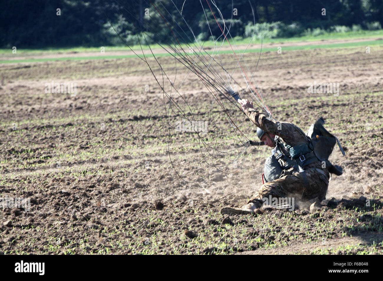 A U.S. paratrooper gets up after landing on the drop zone during Leapfest 2015 in West Kingston, R.I., Aug. 1, 2015. Leapfest is an International parachute competition hosted by the 56th Troop Command, Rhode Island National Guard to promote high level technical training and esprit de corps within the International Airborne community. (U.S. Army Photo by Spc. Joseph Cathey/Released) Stock Photo