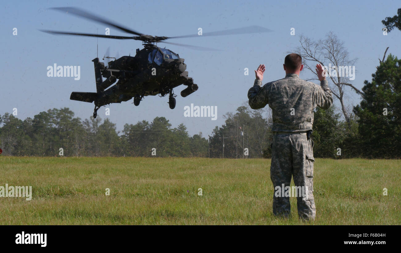 Staff. Sgt. Thomas Reich, a supply sergeant assigned to Company E, 1st Battalion, 149th Aviation Regiment, 185th Aviation Brigade, Mississippi Army National Guard, marshals the landing of an AH-64 Apache helicopter at Camp Shelby Joint Forces Training Center, Miss., on Aug. 3, 2015. The Apache helicopters were landing on a Forward Arming and Refueling Point – an area for combat aircraft to rapidly refuel and rearm simultaneously. Approximately 4,600 soldiers from the Active, National Guard, and Reserve components are partnering in Mississippi for the 155th Armored Brigade Combat Team’s Exporta Stock Photo