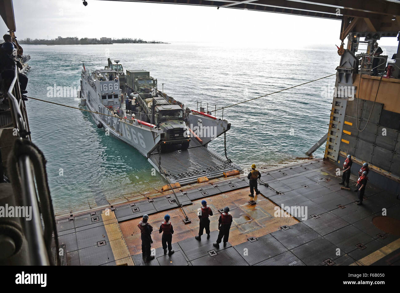 150808-N-KM939-449 SAIPAN HARBOR, Saipan (Aug. 8, 2015) - Vehicles from the 31st Marine Expeditionary Unit (MEU) are unloaded from the well deck of the amphibious dock landing ship USS Ashland (LSD 48) via Landing Craft Utility vehicle during disaster relief efforts in Saipan after Typhoon Soudelor made landfall. Ashland is assigned to the Bonhomme Richard Expeditionary Strike Group and is on patrol in the U.S. 7th Fleet area of operations. Stock Photo