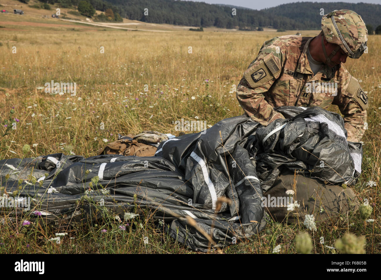 A U.S. Soldier, with the 1st Battalion, 503rd Infantry Regiment, 173rd Airborne Brigade Combat Team  Brigade, repacks his T-11 parachute while conducting airborne operations during exercise Allied Spirit II at the Hohenburg Drop Zone at the U.S. Army’s Joint Multinational Readiness Center in Hohenfels, Germany, Aug. 13, 2015. Allied Spirit is a multinational ground force training exercise designed to increase interoperability between U.S. and NATO forces. Stock Photo