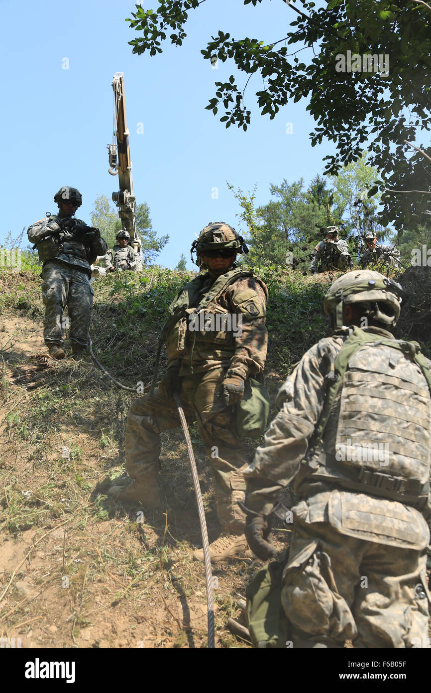 U.S. Soldiers assigned to Alpha Company, 173rd Brigade Support Battalion, 173rd Airborne Brigade Combat Team recover a crashed armored vehicle while conducting catastrophic recovery operations during exercise Allied Spirit II at the U.S. Army’s Joint Multinational Readiness Center in Hohenfels, Germany, Aug. 14, 2015. Allied Spirit is a multinational ground force training exercise designed to increase interoperability between U.S. and NATO forces. (U.S. Army photo by Sgt. Alexandra Hulett/Released) Stock Photo