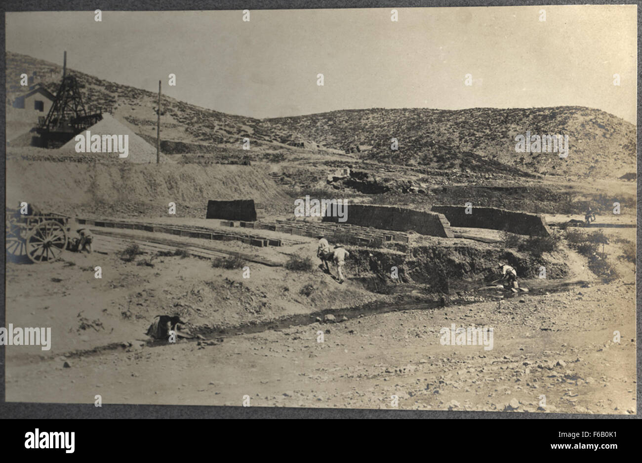 This image depicts native workers constructing adobe structures near ...