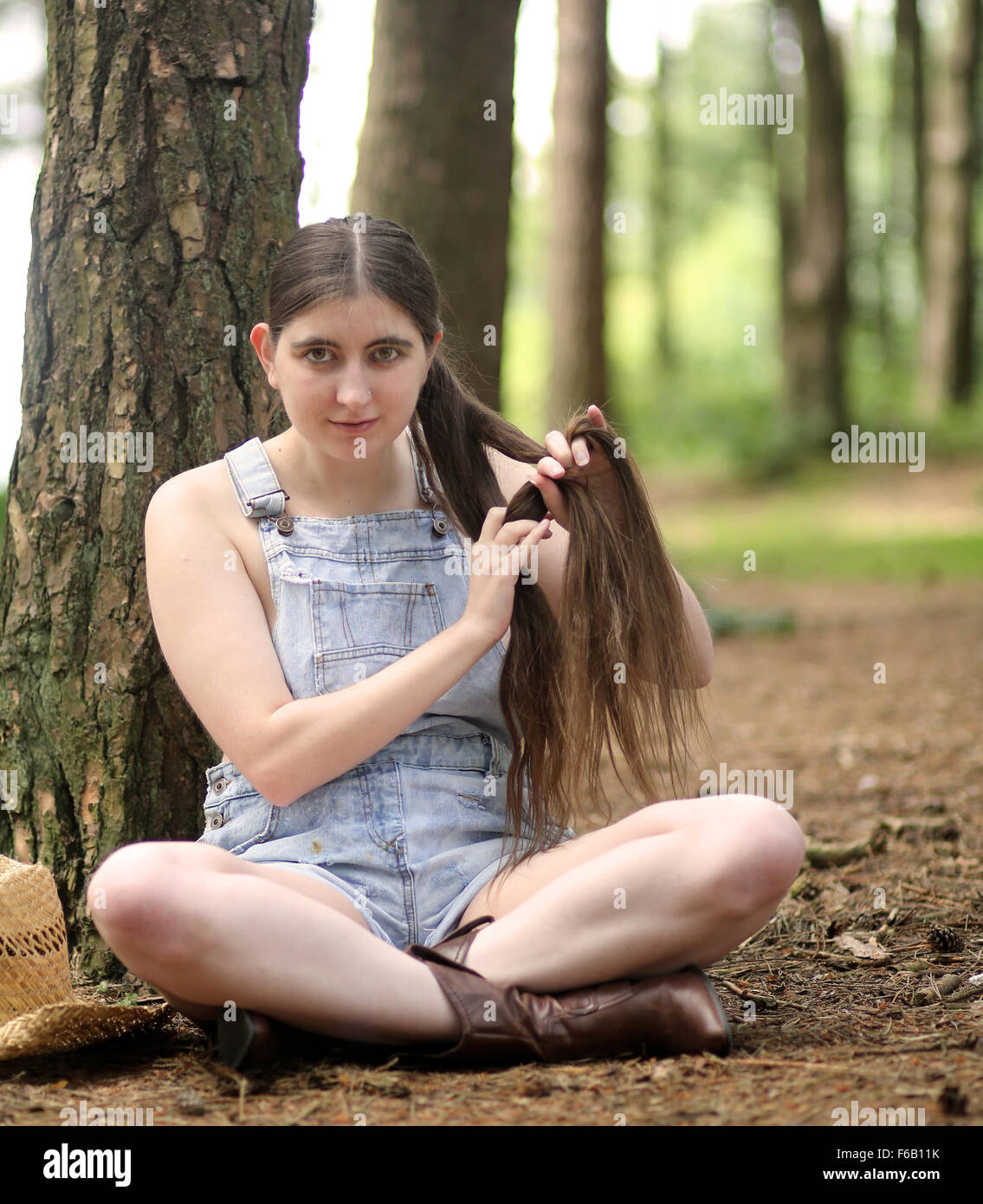 Country backwoods girl in old cut dungaree shorts in the woods, July 2014  Stock Photo - Alamy