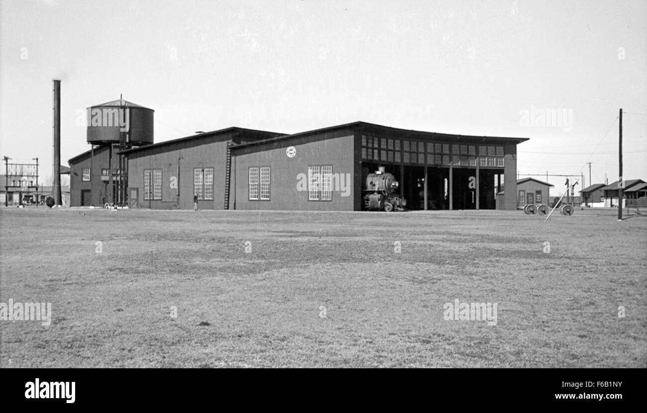 This historical image captures the Southern Pacific (Espee) Roundhouse at Miller Yards in Dallas, Texas, with various SP TNO locomotives visible. The roundhouse was a central hub for train maintenance and operations in the area. Stock Photo