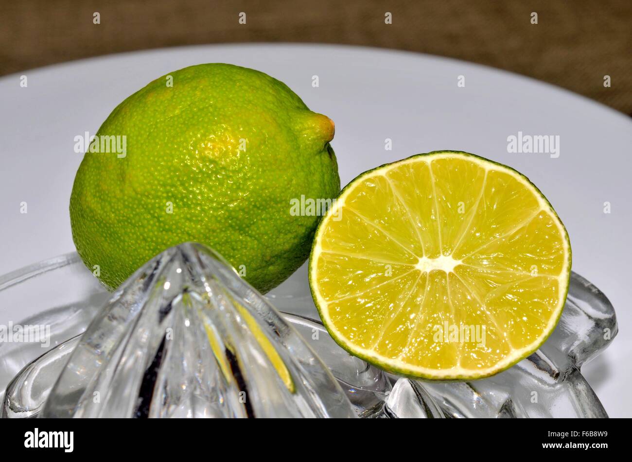 Fresh aromatic lime with juicer, grater and zester. Delicious colorful fruit, wonderful addition to cooked or baked goods. Stock Photo