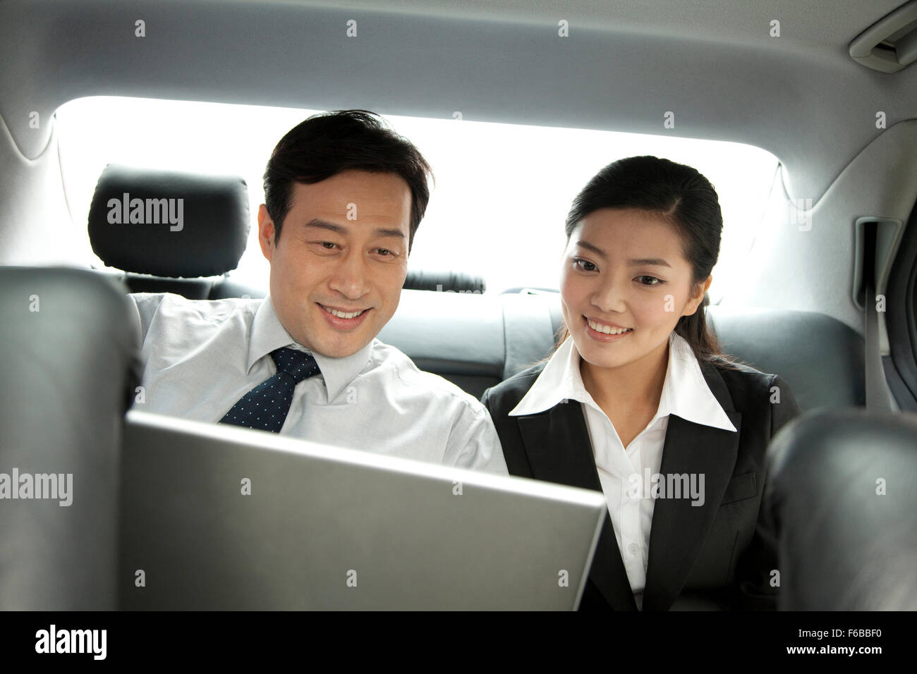 business people working with laptop in the car Stock Photo