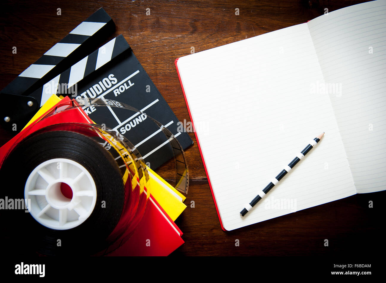 Screenwriter desktop detail with clapper, film reel notebook and pencil Stock Photo