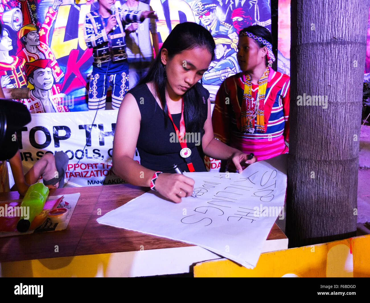 A woman organizer of the event, writing on a placard, stop the killings of the Lumads. The Lumad peoples are a group of indigenous people of the southern Philippines. It is a Cebuano term meaning 'native' or 'indigenous'. The term is short for Katawhang Lumad (literally 'indigenous peoples'), the autonym officially adopted by the delegates of the Lumad Mindanao Peoples Federation (LMPF) founding assembly on 26 June 1986 at the Guadalupe Formation Center, Balindog, Kidapawan, Cotabato, Philippines. It is the self-ascription and collective identity of the indigenous peoples of Mindanao. (Photo b Stock Photo