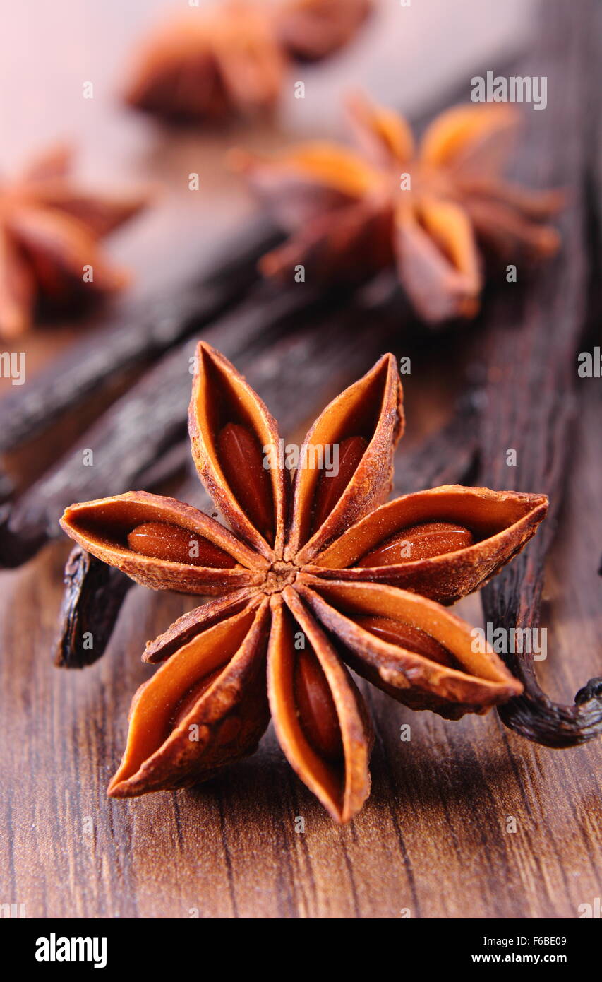 Closeup of fresh star anise and fragrant vanilla sticks pods on wooden