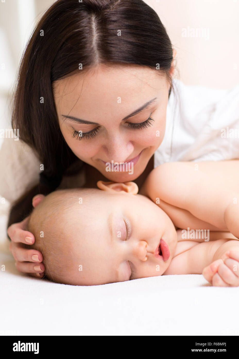 Happy mother looking at sleeping baby Stock Photo