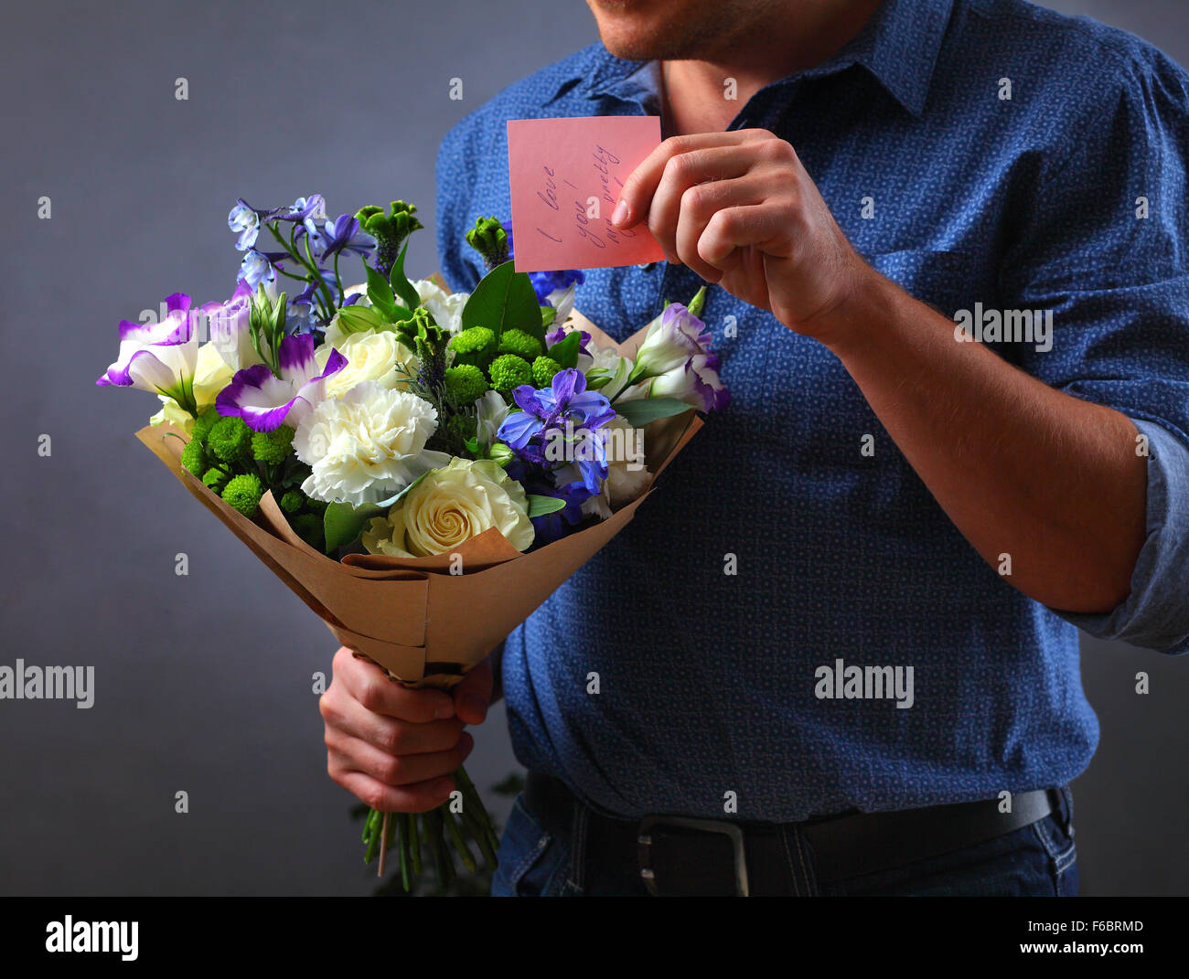 man holding a bouquet of flowers, a man makes a proposal to a woman, a lover of flowers and a ring, love note hidden in the flowers, note mistress, Stock Photo