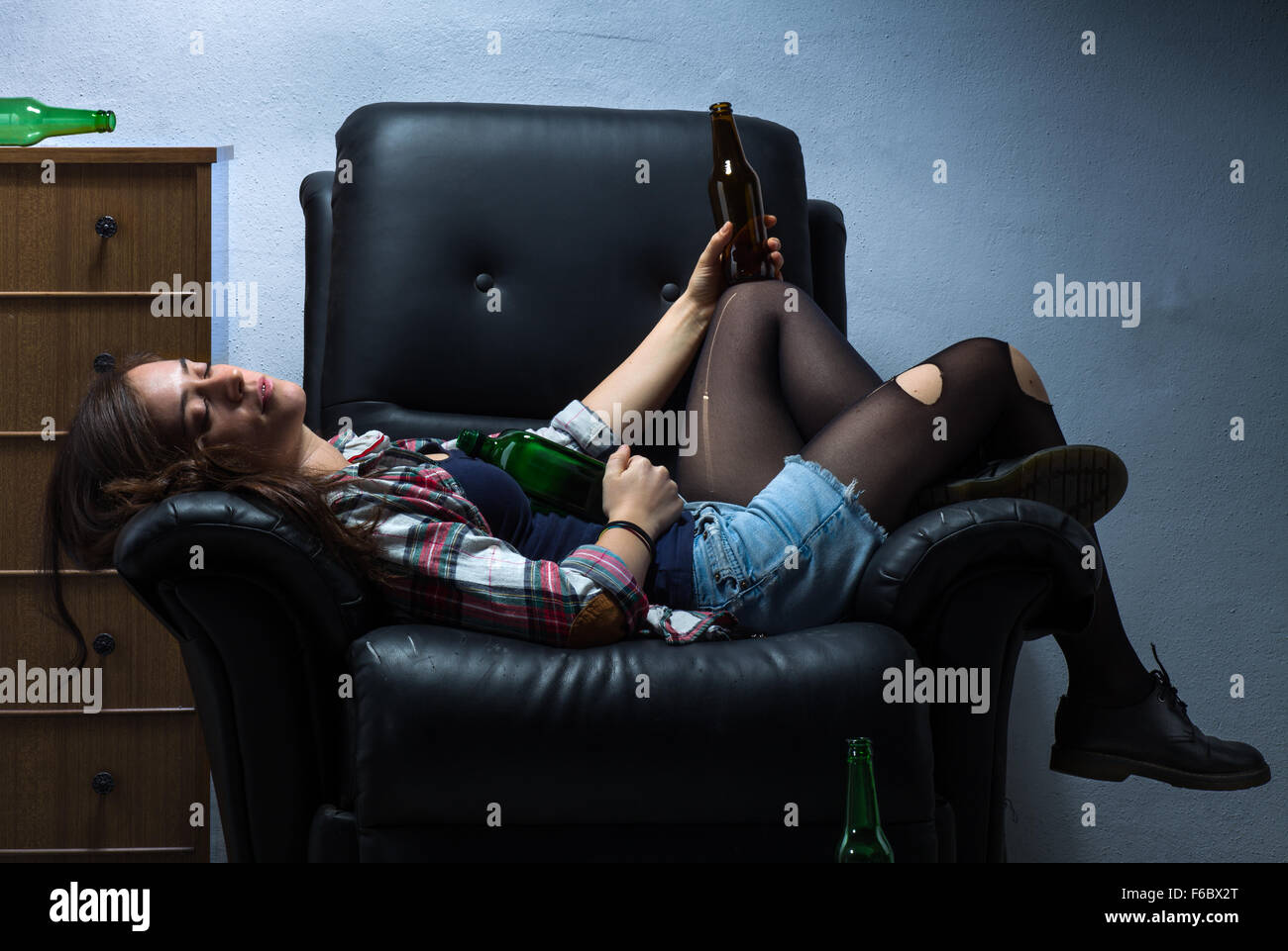 Drunk Woman Sleeping on Armchair with Beer Bottles Stock Photo