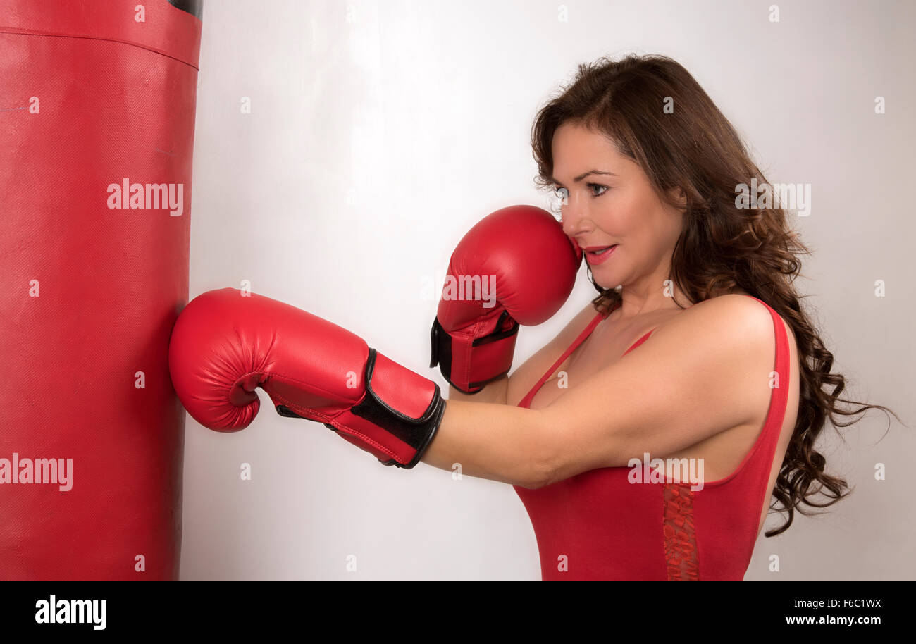 Woman boxer in a gym using a punchbag Stock Photo