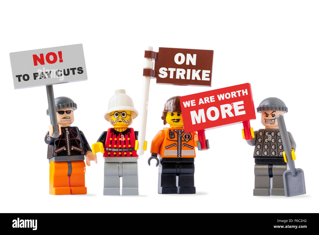Workers on strike concept with four toy figurines isolated on white background and holding signs with protest messages Stock Photo